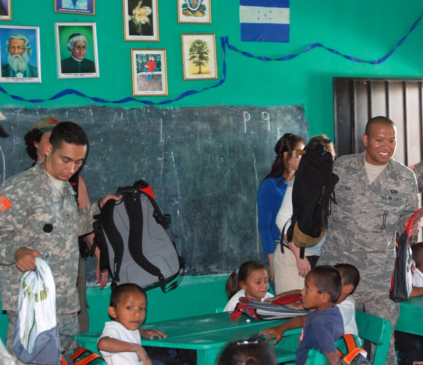 Army Sgt. 1st Class Julio Reyes and Air Force Staff Sgt. Matthew Delgado, from Joint Task Force Bravo, give backpacks with school supplies to children at a school in Humuya, Honduras. The backpacks were donated by children in the United States through the Give a Kid a Backpack organization in Florida.  (U.S. Air Force photo by Tech. Sgt John Asselin)