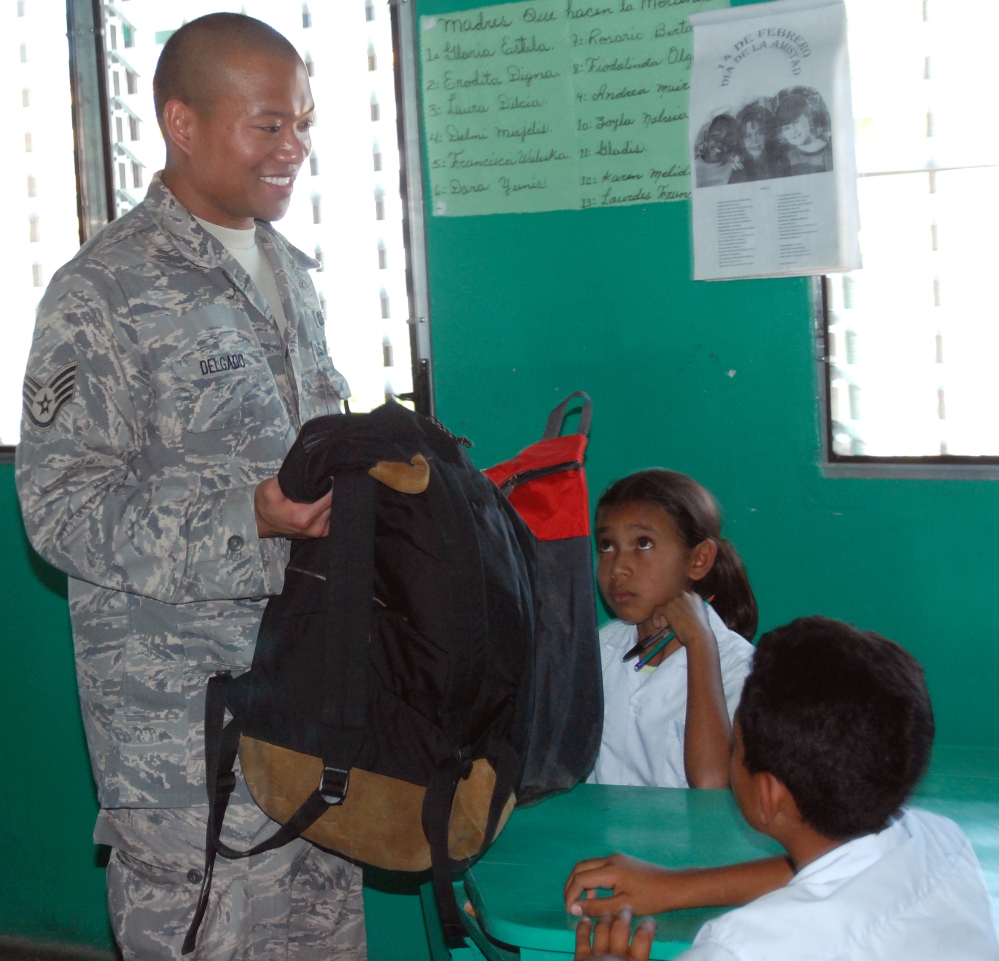 Air Force Staff Sgt. Matthew Delgado, a JTF-Bravo Joint Operations Center controller, give backpacks packed with school supplies to children at a school in Humuya, Honduras. Five representatives from the Give a Kid a Backpack organization in Florida and 15 volunteers from JTF-Bravo distributed more than 700 backpacks packed with school supplies to children at five schools and two orphanages in the Comayagua and La Paz districts. (U.S. Air Force photo by Tech. Sgt John Asselin)