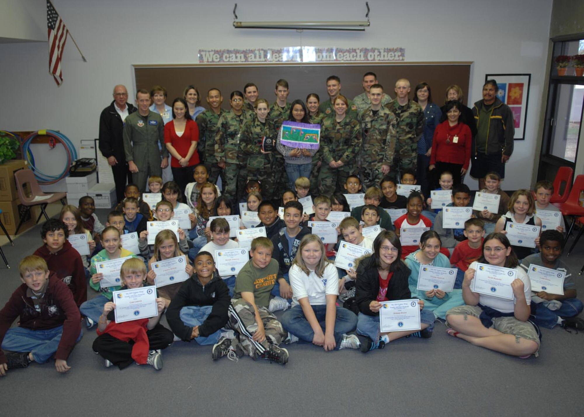 Celeste Vasquez, the winner of the Child Abuse prevention poster contest, poses for a photo with all of the fifth graders at Borman elementary school, the Airmen that helped judge the contest, and Col. Kent Laughbaum, 355th Fighter Wing commander. 