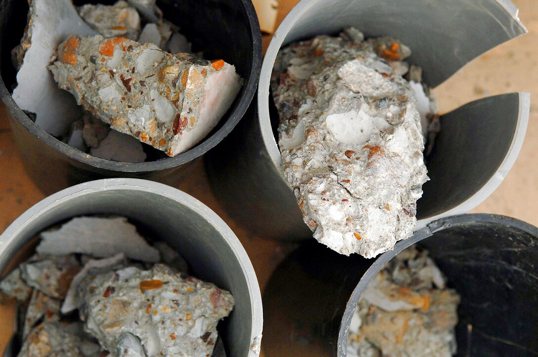 Pieces of broken cylinder samples, taken from the new Housing 6 area shoppette foundation, sit after being strength tested Feb. 21 at Balad Air Base, Iraq. The test, performed by engineering assistants, is vital to the safety of Airmen and aircraft every day. Without constant surveys and tests the Air Force runs the risk of allowing sub-standard materials to be used on projects that are used on a daily basis. (U.S. Air Force photo/Senior Airman Julianne Showalter) 
