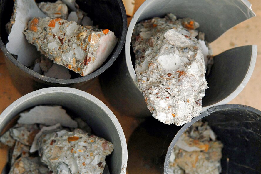 Pieces of broken cylinder samples, taken from the new Housing 6 area shoppette foundation, sit after being strength tested Feb. 21 at Balad Air Base, Iraq. The test, performed by engineering assistants, is vital to the safety of Airmen and aircraft every day. Without constant surveys and tests the Air Force runs the risk of allowing sub-standard materials to be used on projects that are used on a daily basis. (U.S. Air Force photo/Senior Airman Julianne Showalter) 