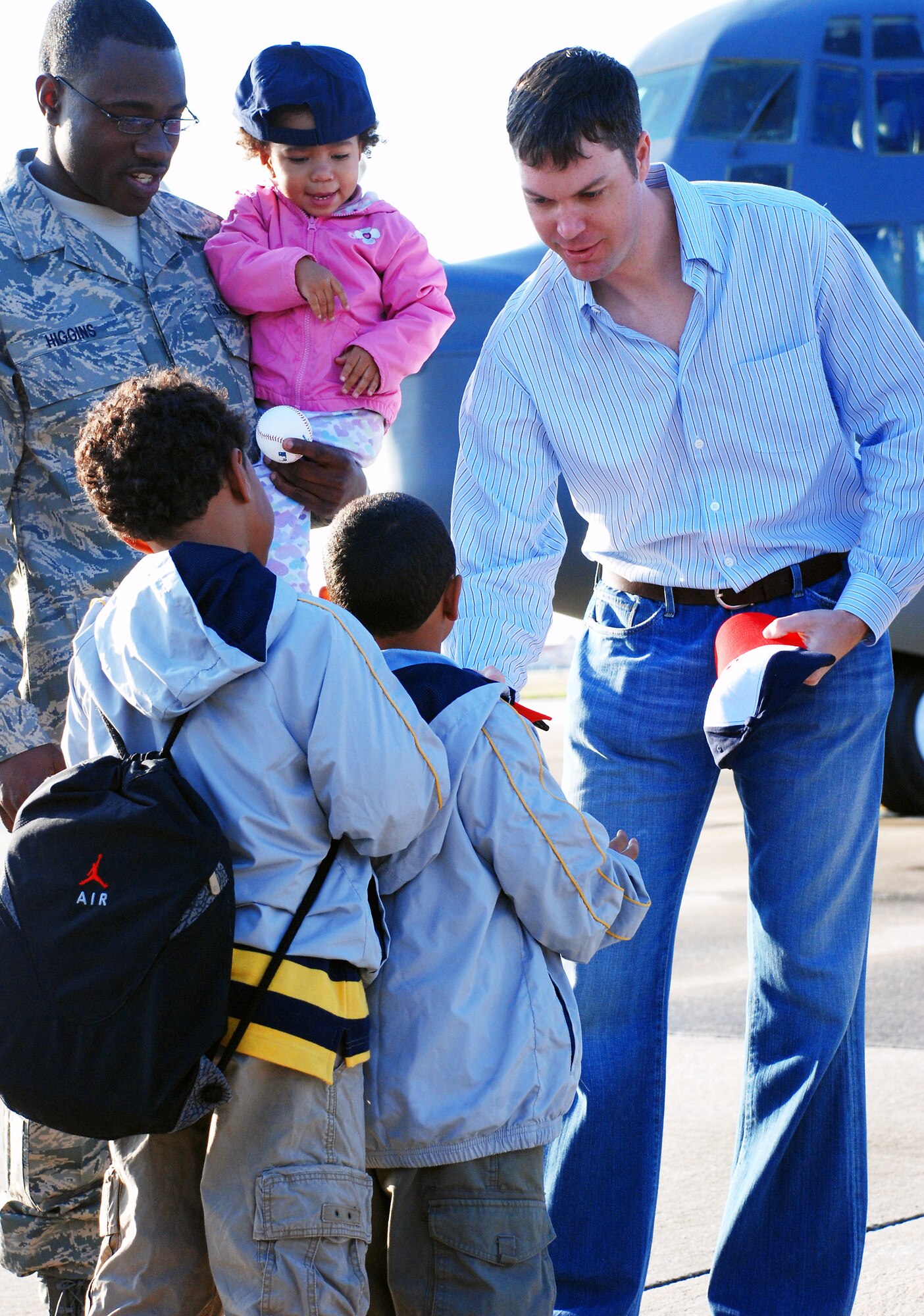 John Patterson, a pitcher for Major League Baseball's Washington Nationals, hands out hats Feb. 20 to children of deploying Air Force reservists at Patrick Air Force Base, Fla.  The Nationals play their spring-training games at nearby Space Coast Stadium. (U.S. Air Force photo/Staff Sgt. Paul Flipse)