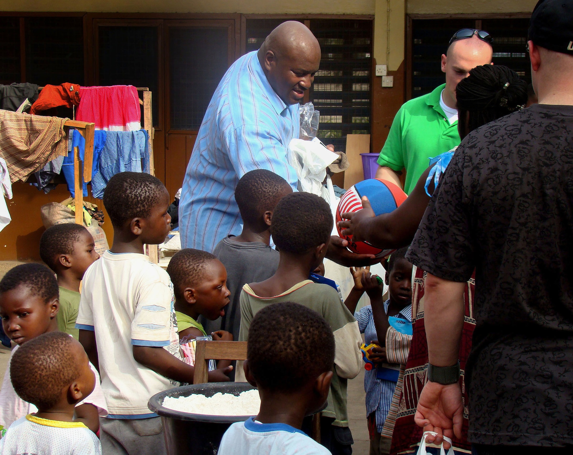 Master Sgt. Kevin Coleman hands out toys to orphaned children at the Osu Children's Home Feb. 18 in Accra, Ghana. Twenty-five Airmen visited the home to hand out more than $500 worth of supplies they purchased through personal donations. The Airmen are part of a joint task force providing infrastructure, aircraft and personnel in support of President George Bush's visits to Benin, Tanzania, Rwanda, Ghana and Liberia Feb. 16 through 21. Sergeant Coleman is a Joint Task Force West weather craftsman. (U.S. Air Force photo/Tech. Sgt. Denise Johnson)