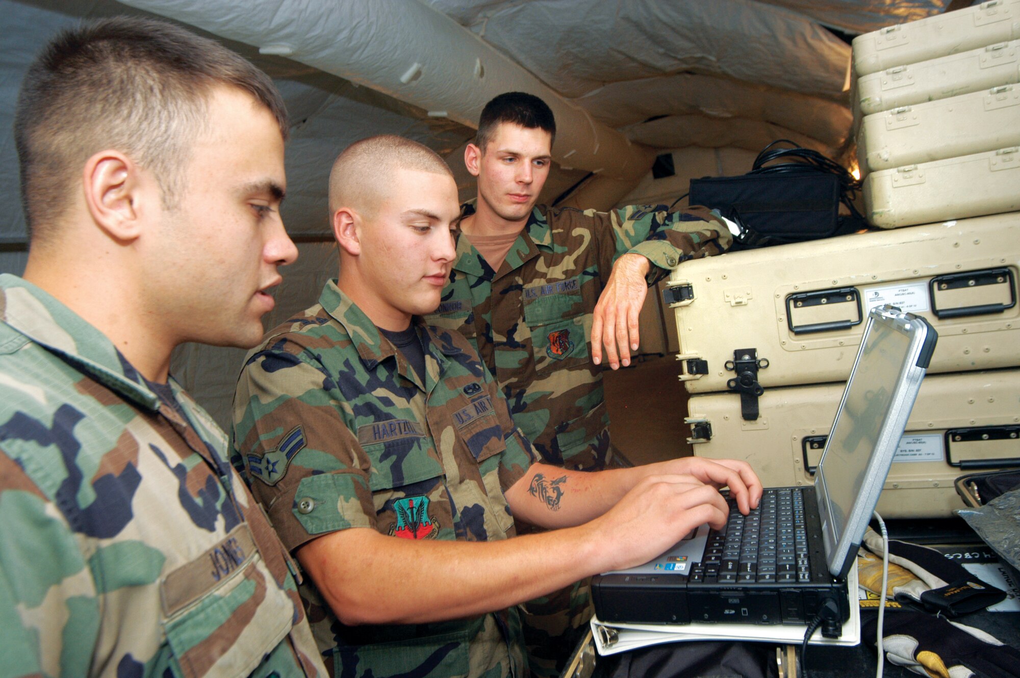 SrA Joshua Jones, A1C Cody Hartzell, and A1C Michael O'Connor configure the router for their internal communication network during the 5th CCG's exercise Oct. 17. The exercise was in preparation for their ORI.  U. S. Air Force photo by Sue Sapp   