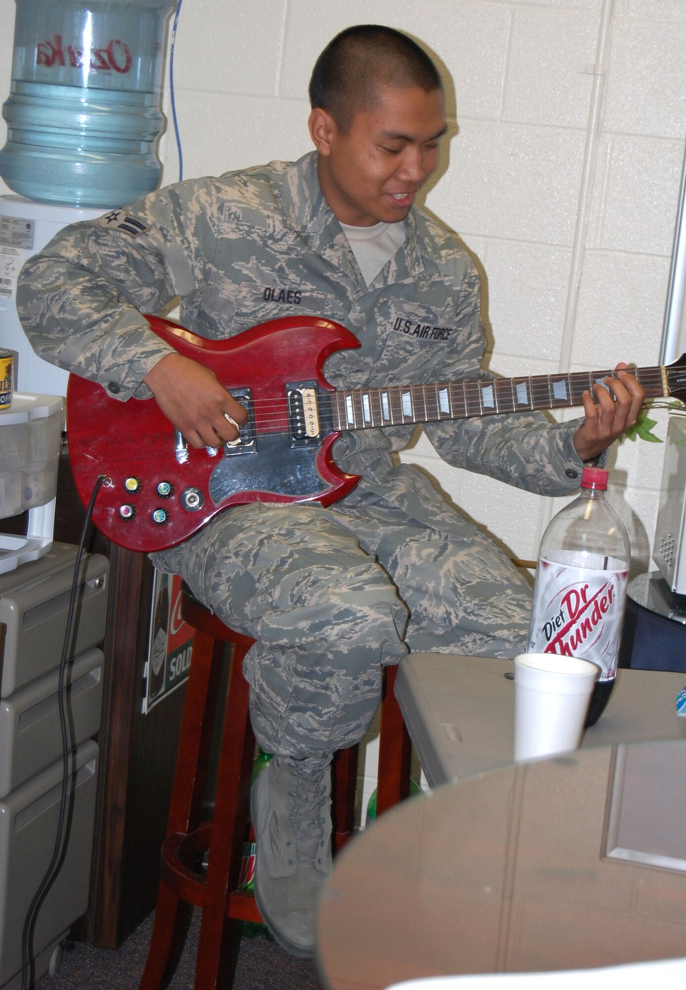 LAUGHLIN AIR FORCE BASE, Texas—Airman 1st Class Ron Olaes, 86th Flying Training Squadron, plays the guitar while Airmen residing in the dorms treat themselves to fried chicken and biscuits during the “Meet and Eat” gathering at Chaplain (Capt.) Shannon Workman’s office Feb. 19. Chaplain Workman hosts a social gathering for all single airmen living in the dorms here regularly. (U.S. Air Force photo by Airman 1st Class Sara Csurilla)
