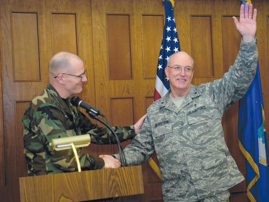 Col. Paul Ackerley, 316th Wing commander, shakes the hand of Ch. (Brig. Gen.) Cecil R. Richardson, Air Force Deputy Chief of Chaplains, the guest speaker at the National Prayer Luncheon at Andrews Air Force Base, Md., on Feb 15. The luncheon included readings from Hebrew, Islamic and Christian scriptures and a speech from Chaplain Richardson entitled "In God We Trust".  (US Air Force/SrA Renae Kleckner)