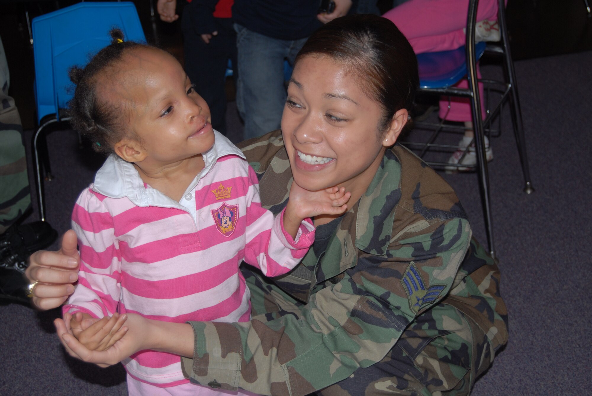 (Left) Senior Airman Marivic-Len Marin, 43rd Airlift Wing, plays with a little girl after delivering boxes of toys to the Dorothy Spainhour Center Feb. 13. in Fayetteville, N.C.  (U.S. Air Force Photo by Airman 1st Class Mindy Bloem)
