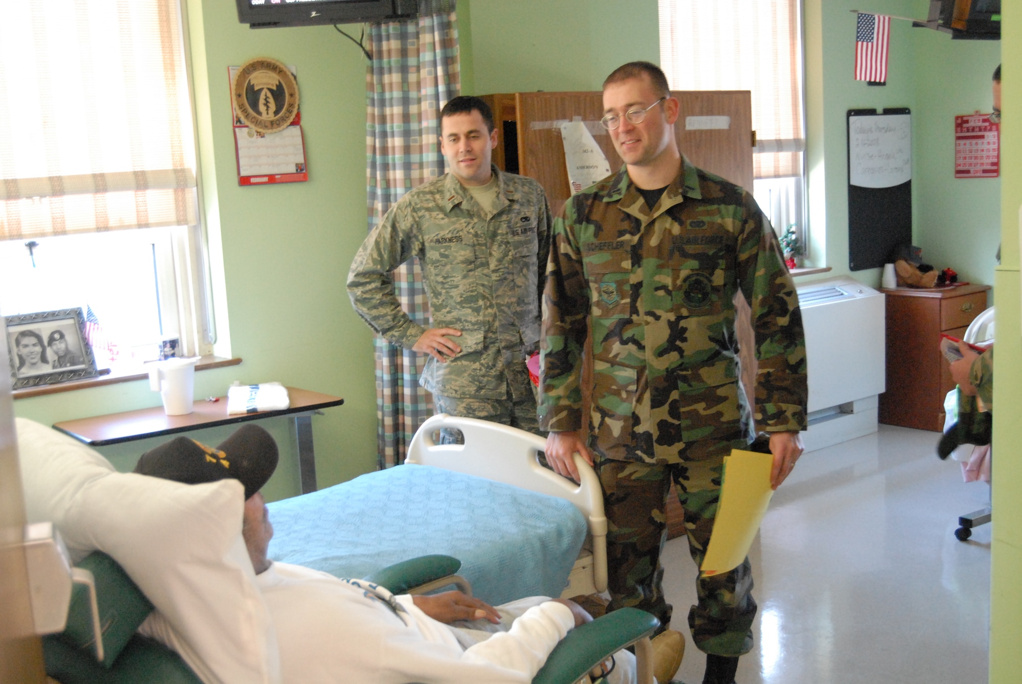 (Left) 2nd Lt. Eric Harkness, 743rd Aircraft Maintenance Squadron, and 1st Lt. Eric
Scheffler, 43rd Civil Engineer Squadron, talk to a veteran during a visit made by Pope
Airmen to the Veterans Affairs Medical Center in Fayetteville, N.C. Feb. 14.  (U.S. Air Force Fhoto by 2nd Lt. Chris Hoyler)