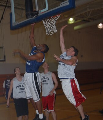 Brandon Freeman, 43rd Maintenance Squadron, attempts a layup while Kasey Crews, 43rd Mission Support Squadron, tries for the rejection from behind. 43rd MXS started the game on an 18-5 run, but lost 49-44. (U.S. Air Force Fhoto by 2nd Lt. Chris Hoyler)