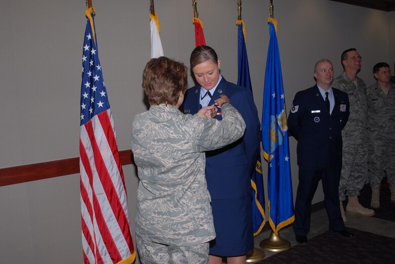 Col. Merrily Madero, 17th Training Wing vice commander, pins a fire protection badge on Airman Basic Jessica Morehouse during a special graduation ceremony Feb. 14. (U.S. Air Force photo by Staff Sgt. Angela Malek)