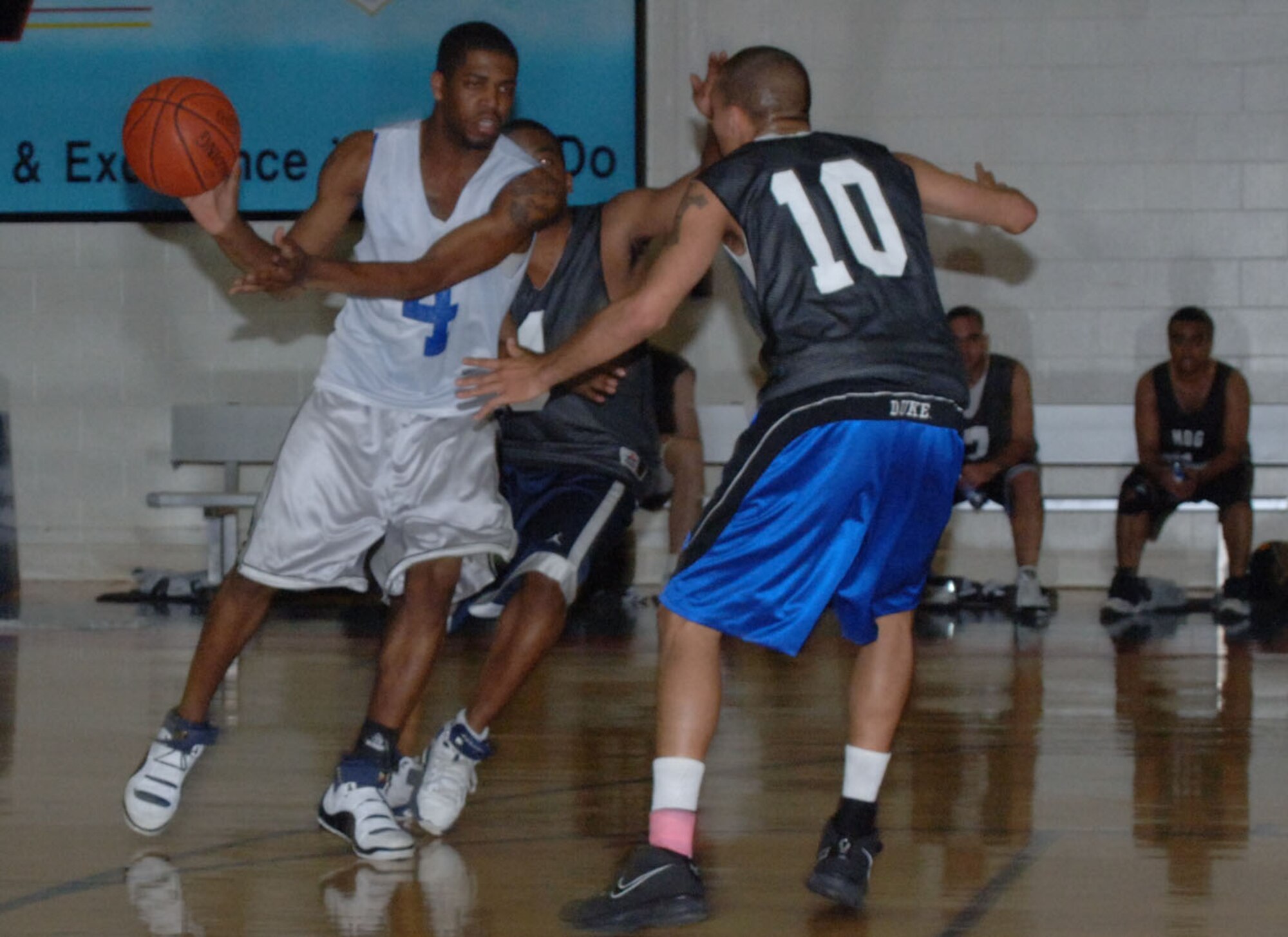 Jonathan Snowden, 37th Flying Training Squadron, look for an open pass as two 14th Medical Group defenders surround him in intramural basketball action Tuesday night. The 37th/41st Flying Training Squadron team was defeated by the 14th MDG for the base championship trophy. (U.S. Air Force photo by Airman 1st Class Danielle Hill)