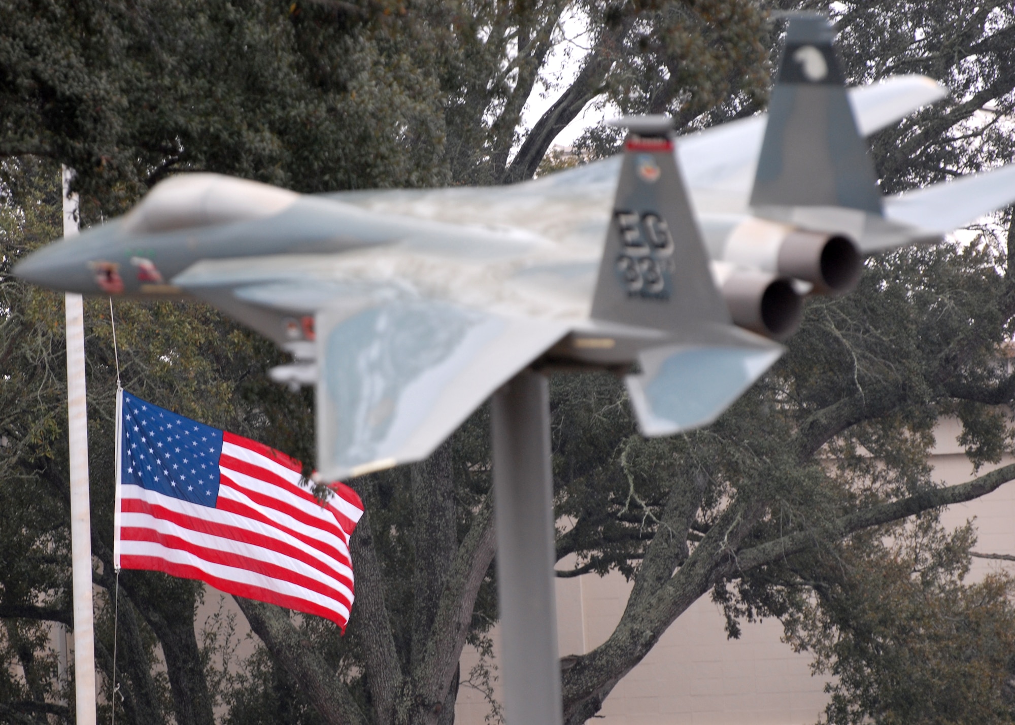 EGLIN AIR FORCE BASE, Fla. -- The American Flag in front of the 33rd Fighter Wing's headquarters building flies at half staff in honor of 1st Lt. Ali Jivanjee, 58th Fighter Squadron pilot, who died in the Feb. 20 crash of two F-15Cs over the Gulf of Mexico. All flags on Eglin are flying at half staff. An Interim Safety Board has convened at the 33rd FW to begin investigating the incident. (U.S. Air Force photo  by Staff Sgt. Mike Meares)