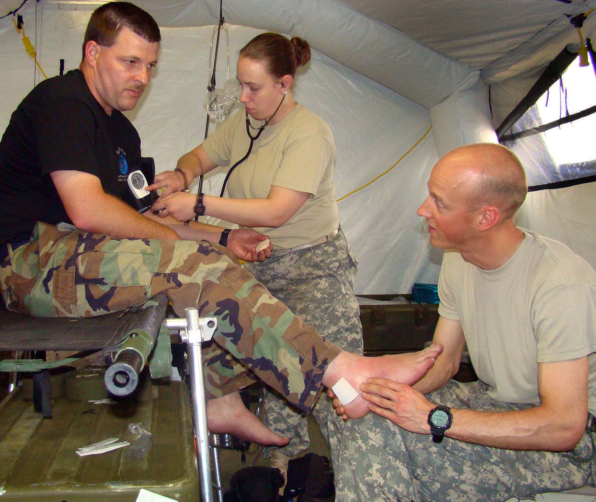 ACCRA, Ghana – A U.S. Army primary care medical team tend to a U.S. Air Force patient in the field clinic here Feb. 19. Army Capt. Peter Henning, the Joint Task Force West Primary Care Team lead, takes a look at Air Force Staff Sgt. Jason Creech's ankle. Army Sgt. Elizabeth Feltz, JTFW Primary Care medic, takes Sergeant Creech's blood pressure and a health history during the appointment. Sergeant Creech is a JTFW crew chief. U.S. Armed Forces members are in Accra as part of a joint task force providing infrastructure, aircraft and personnel in support of the President's visits to Benin, Tanzania, Rwanda, Ghana and Liberia Feb. 16 to 21. 