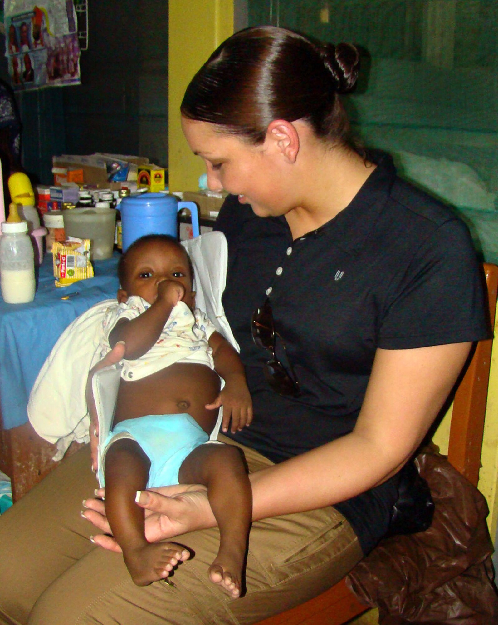 Tech. Sgt. Sarah Gordon holds an orphaned infant at the Osu Children's Home in Accra, Ghana, Feb. 18. Sergeant Gordon is the Joint Task Force West personnelist in charge of contingency operations. She is just one of twenty-five Airmen who visited the home to hand out more than $500 dollars worth of needy supplies they purchased through personal donations. The Airmen are part of a joint task force providing infrastructure, aircraft and personnel in support of U.S. President George Bush's visits to Benin, Tanzania, Rwanda, Ghana and Liberia Feb. 16 to 21.