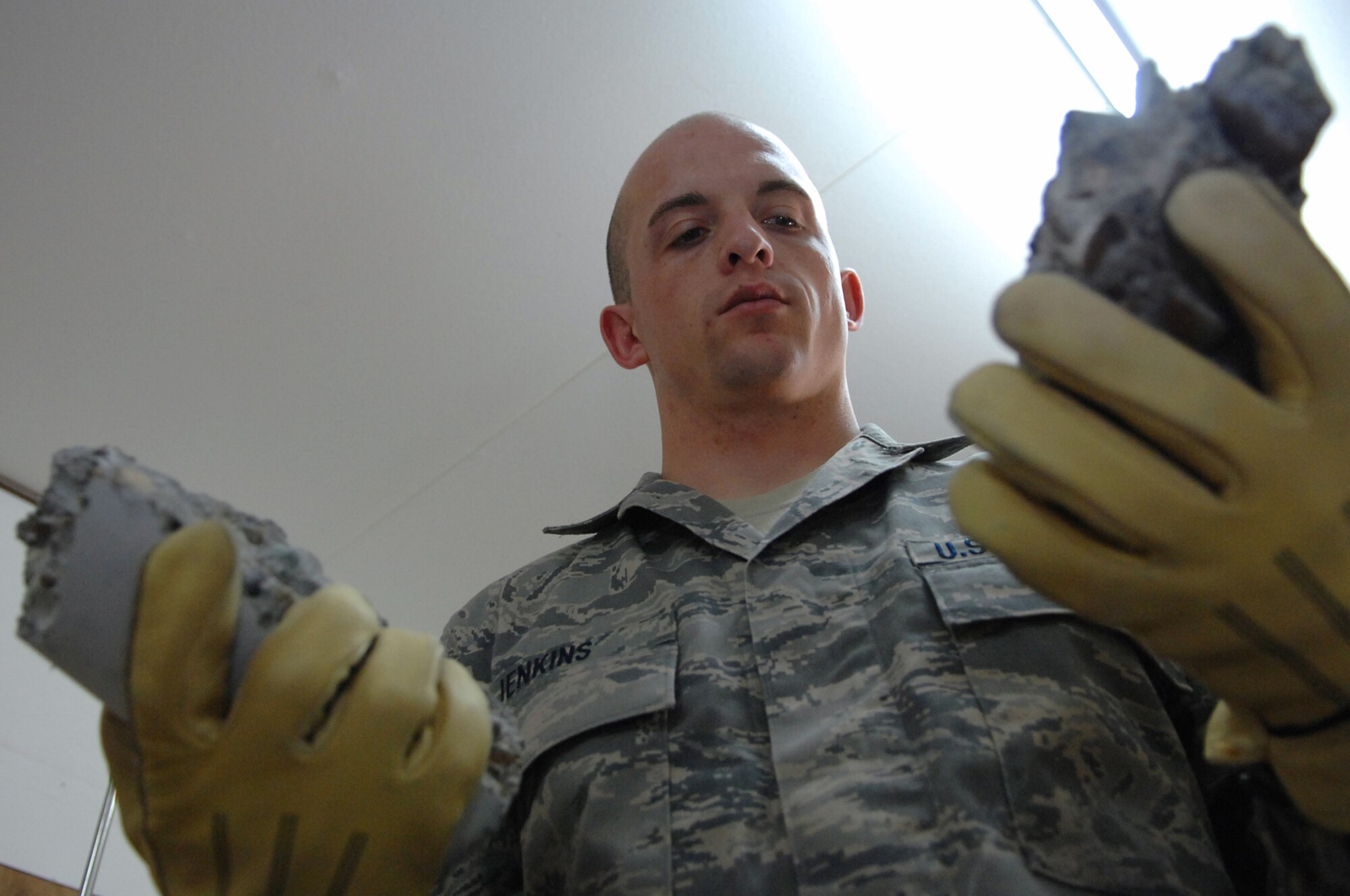 BALAD AIR BASE, Iraq -- Staff Sgt. Jack Jenkins, 332nd Civil Engineer Squadron engineering assistant, examines the broken pieces of a concrete cylinder sample taken from the new Housing 6 area shoppette foundation here, Feb. 21. Sergeant Jenkins is deployed from Ellsworth Air Force Base, S.D. (U.S. Air Force photo/ Senior Airman Julianne Showalter)