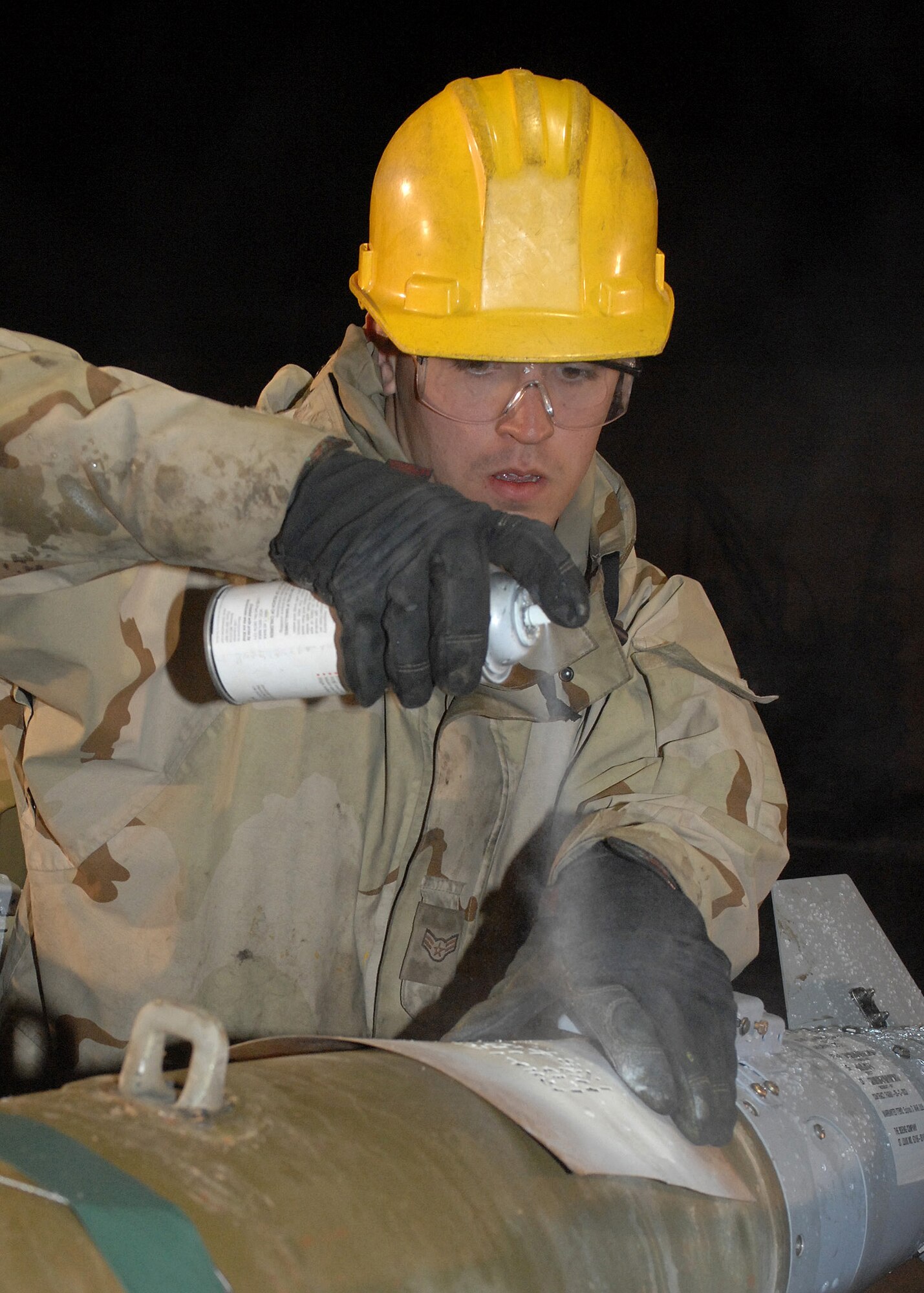 BAGRAM AIR BASE, Afghanistan - Airman 1st Class Jedediah McClain, a 455th Expeditionary Maintenance Squadron AMMO troop, paints fuse settings on bombs for identification by loaders and pilots here Feb 14. McClain's home unit is the 4th Equipment Maintenance Squadron, Seymour Johnson Air Force Base, N.C. (U.S. Air Force photo by Master Sgt. Demetrius Lester)