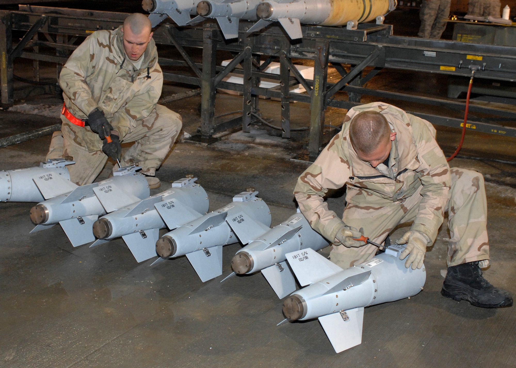 BAGRAM AIR BASE, Afghanistan - Airman 1st Class Jedediah McClain (left), and Airman 1st Class Zack Demeter, 455th Expeditionary Maintenance Squadron, reset umbilical connectors on the fins for GBU-38 bombs here Feb. 14. McClain's home unit is the 4th Equipment Maintenance Squadron, Seymour Johnson Air Force Base, N.C. and Demeter is from the 52nd Equipment Maintenance Squadron, Spangdhalem Air Base, Germany. (U.S. Air Force photo by Master Sgt. Demetrius Lester)