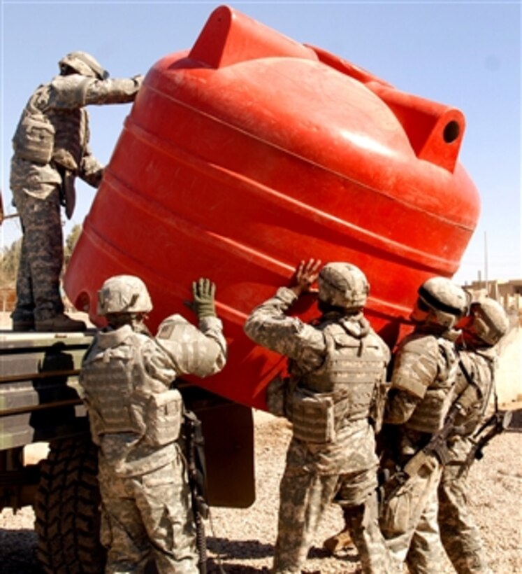 Soldiers assigned to the 3rd squad, 1st platoon, 236th Military Police Company, Texas National Guard unload a container for a shower unit that was provided to them by the 716th Military Police Battalion, 18th Military Police Brigade, Multi-National Division-Baghdad. This shower unit will provide them 5 additional shower stalls for the squad. 