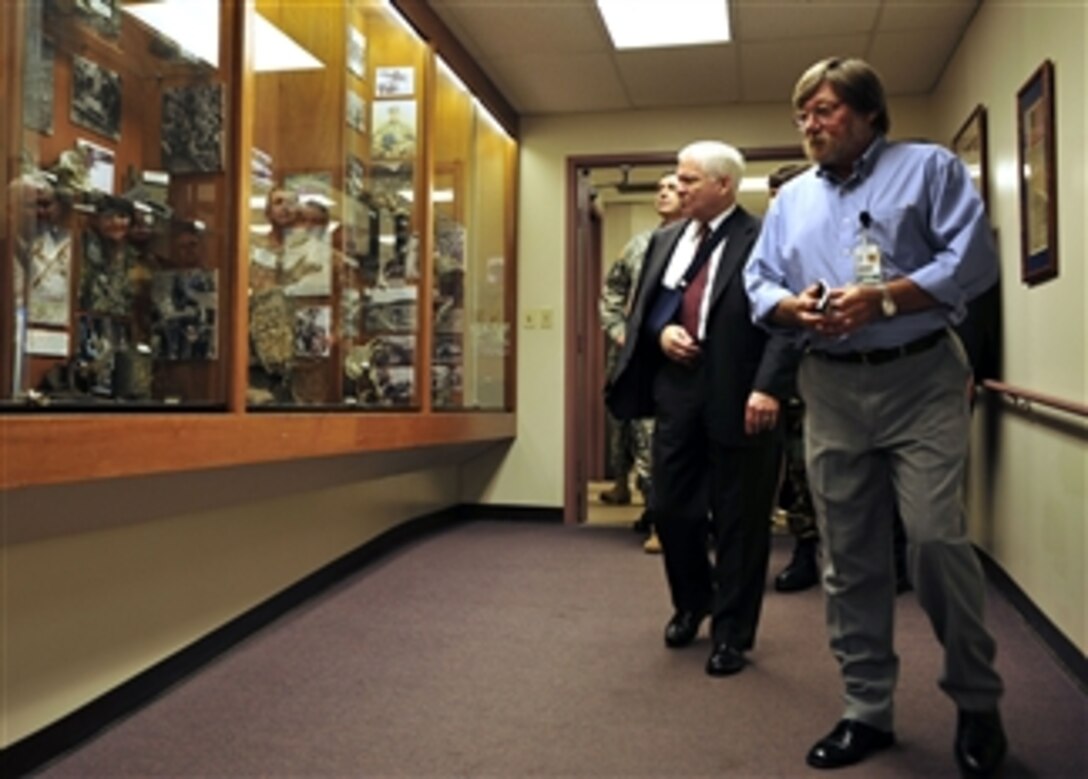 Defense Secretary Robert M. Gates listens to Dr. Greg Fox as he tours the Joint POW/MIA Accounting Command on Hickam Air Force Base, Hawaii, Feb. 21, 2008. 