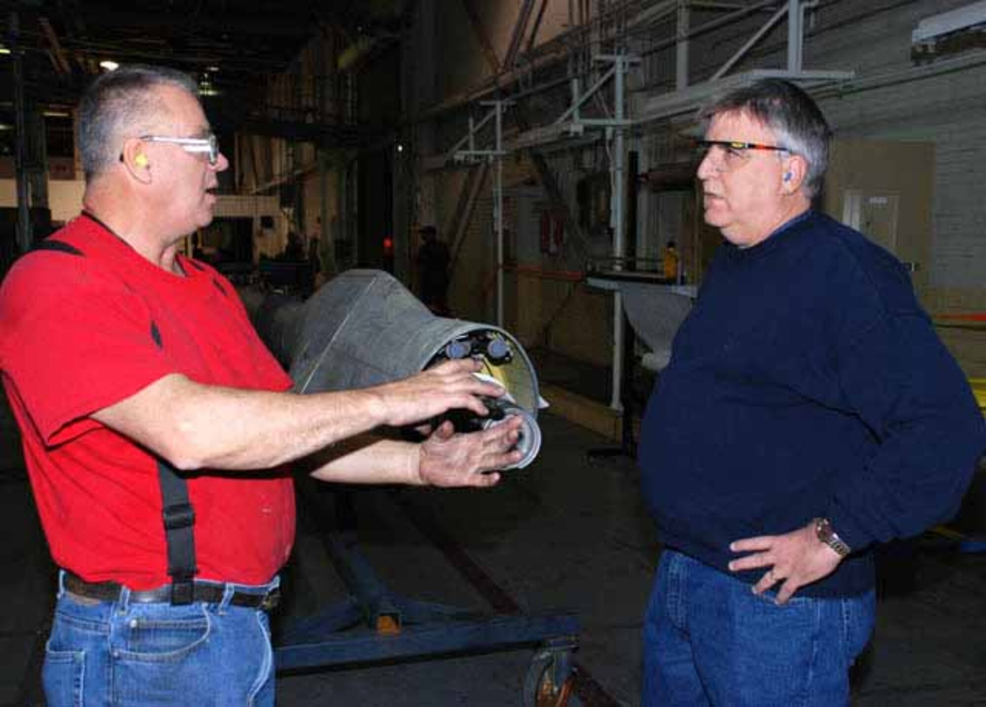 DSCR forward presence customer account specialist Joe McRoy (right) talks with aircraft mechanic Joe Cram about work on a refueling boom for a tanker at Oklahoma City Air Logistics Center. McRoy works commodities issues for DLA's largest aviation customer. (Photo by Debra Bingham)
