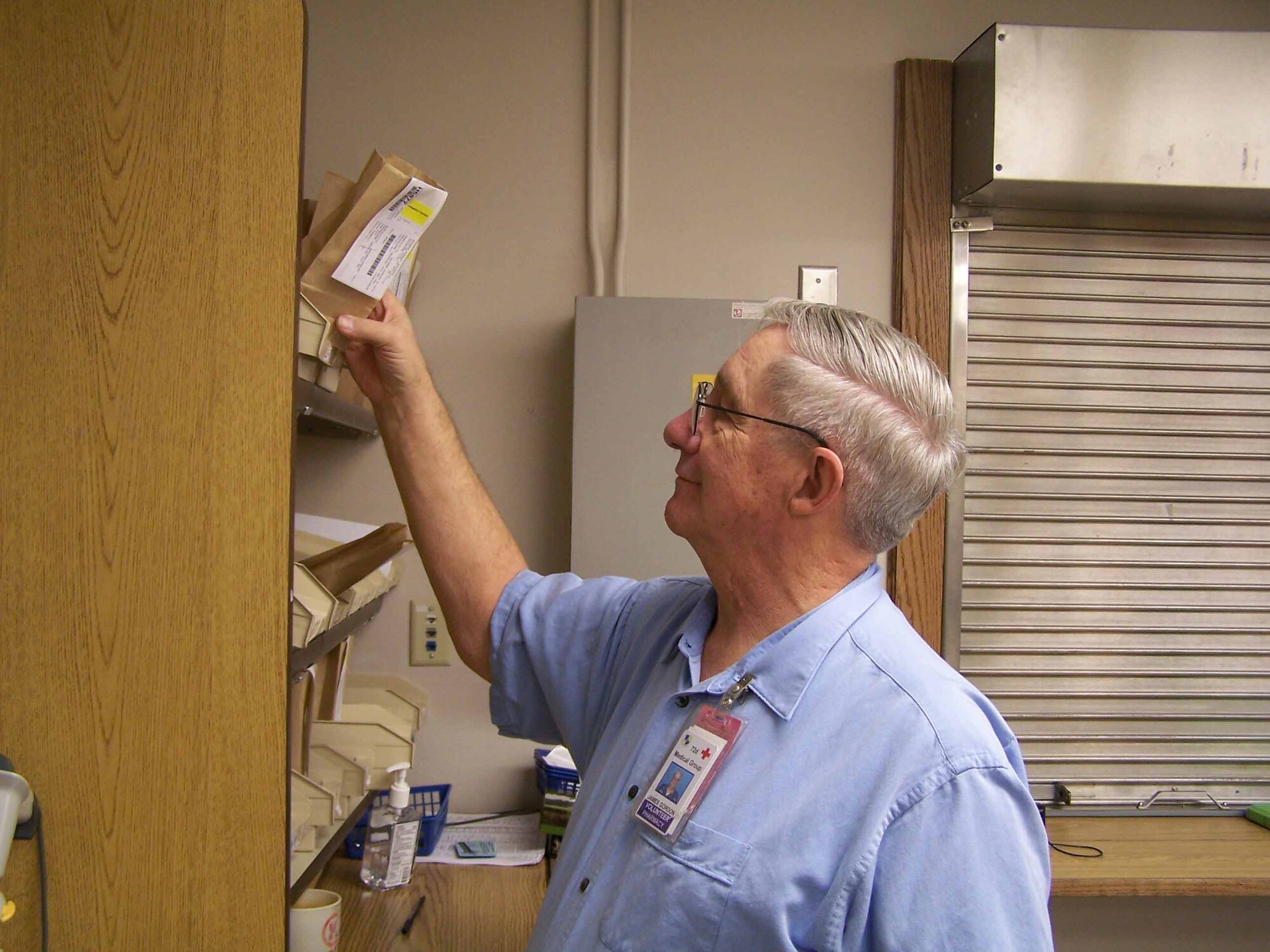 James Gordon, a volunteer at the 72nd MDG, pulls a patient's prescription.  (Courtesy photo)