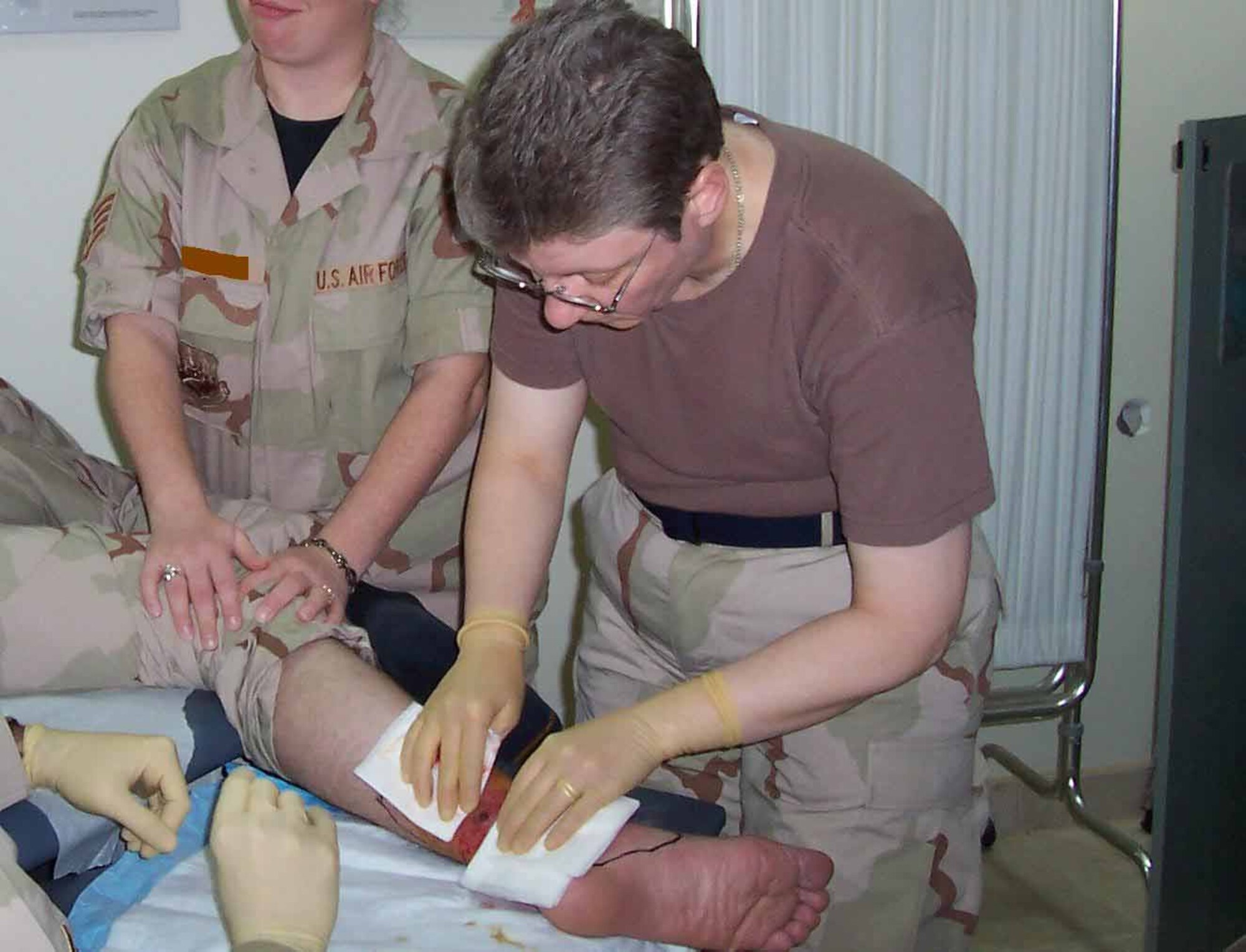 Maj. (Dr.) Dillard performs a minor procedure on an Airman's infection in Southwest Asia.  (Courtesy photo)