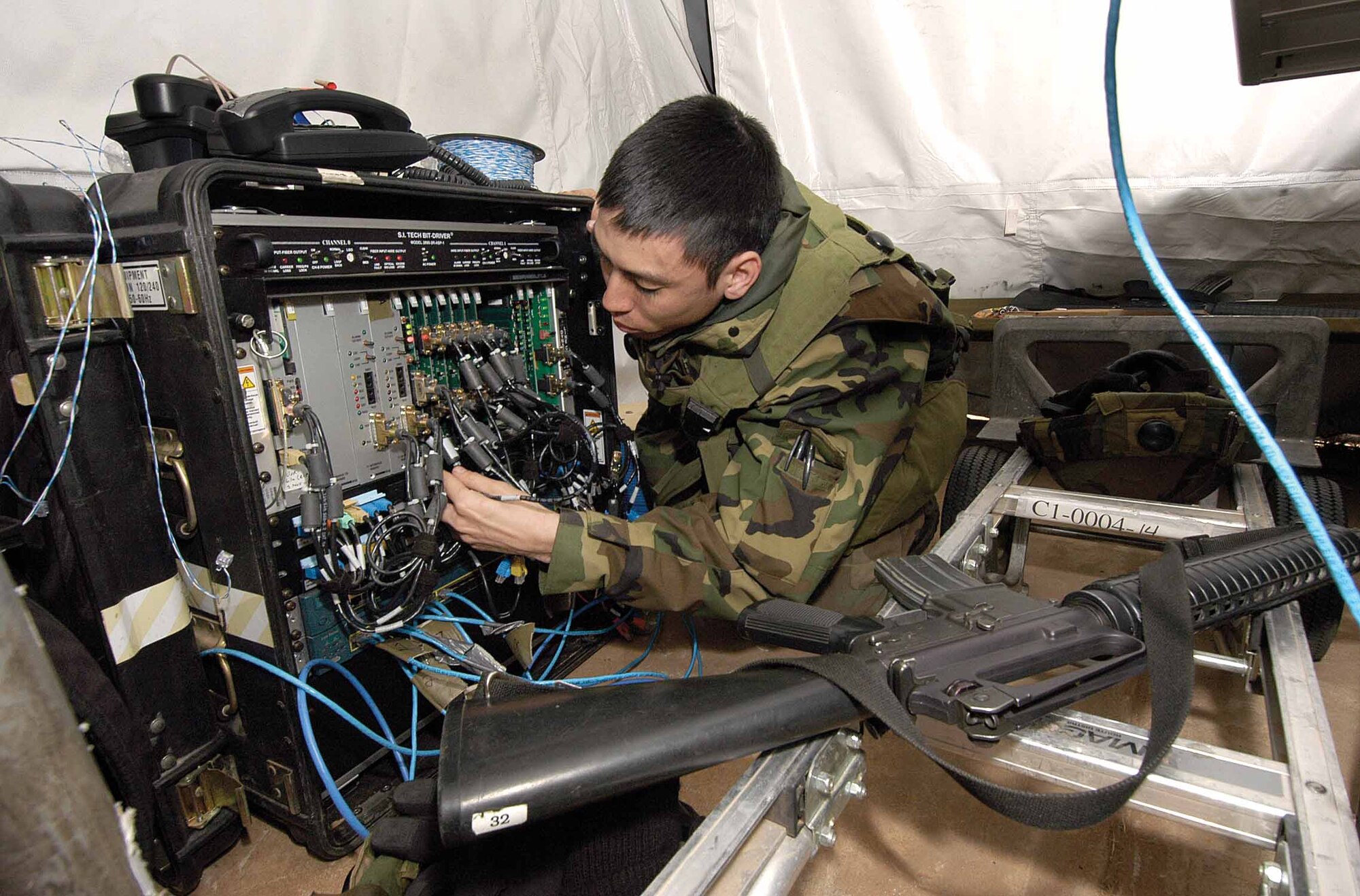 Senior Airman William Page, 31st Combat Communications Squadron, installs lightning protection on a Basic Access Module, a system providing voice and internet to exercising squadrons during recent Resolute Warrior training at Glenwood Training Area.  The BAM fed eight tents with 18 phone lines and 20 internet drops.  (Air Force photo by Margo Wright)

