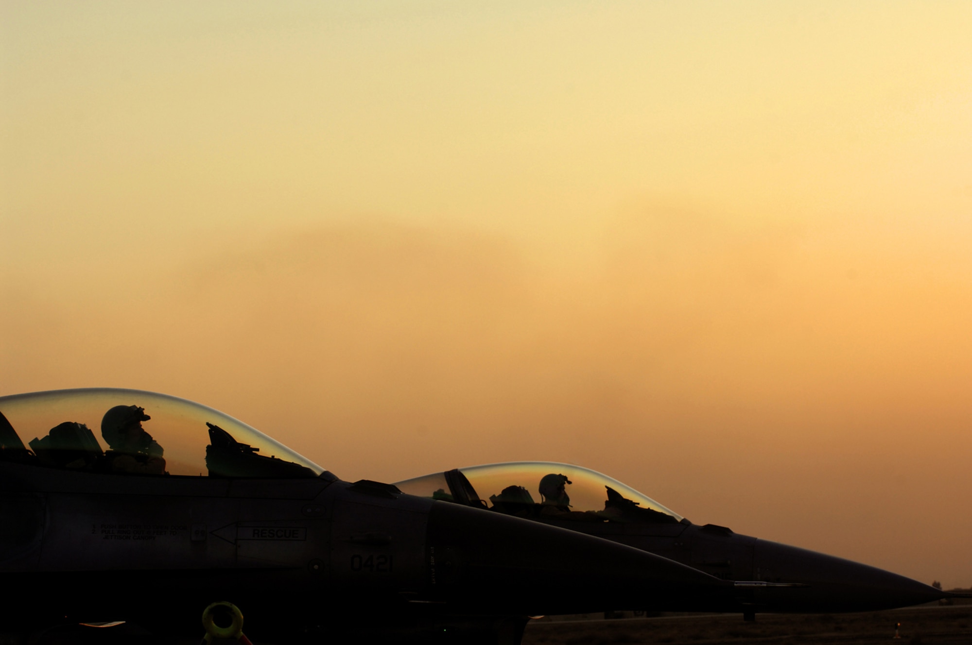 BALAD AIR BASE, Iraq -- Two F-16 Fighting Falcon pilots from the 23rd Expeditionary Fighter Squadron wait to depart here, Feb. 21. Both pilots are deployed from Spangdahlem Air Base, Germany. (U.S. Air Force photo/ Senior Airman Julianne Showalter)