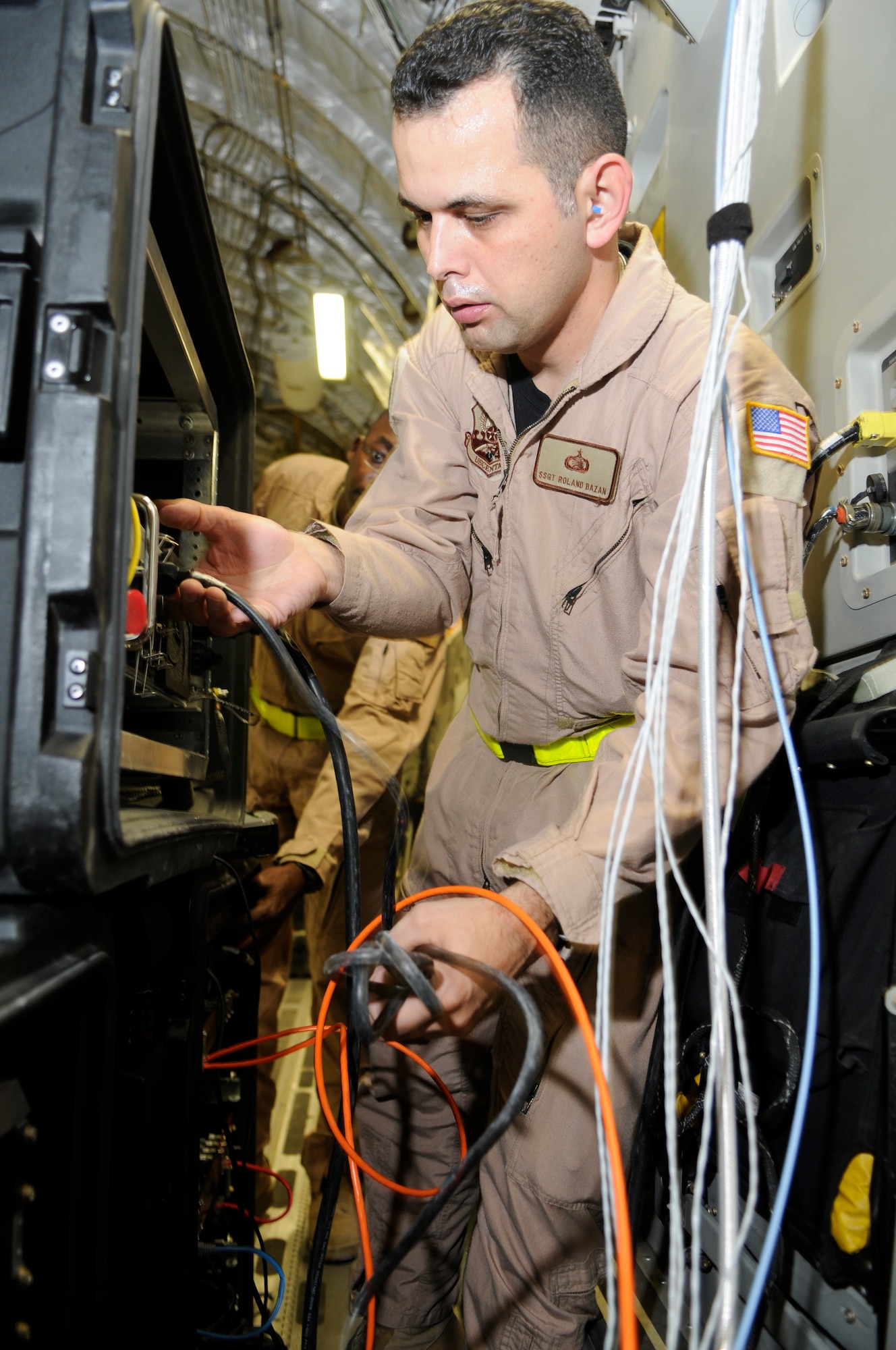 Staff Sgt. Roland Bazan connects network cables to the Viper System while on a C-17 here  Feb 19. He ensures distinguished visitors will have secure and non-secure internet access while on the aircraft.  (U.S. Air Force photo/Tech. Sgt. Johnny L. Saldivar)