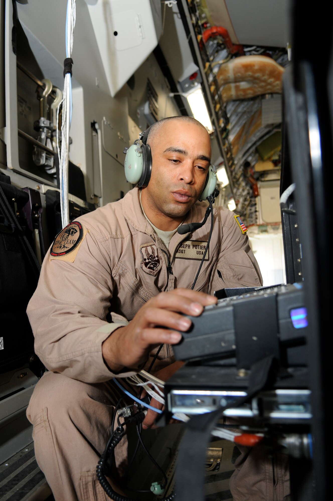 Master Sgt. Joseph Potier, 379th Expeditionary Communications Squadron, talks to the comm. focal point while on a C-17 at a Southwest Asia air base Feb 19. He performs function checks to ensure distinguished visitors can make secure calls through the Viper system. He is from Leonville, LA, deployed from Lackland Air Force Base, Texas. (U.S. Air Force photo/Tech. Sgt. Johnny L. Saldivar)