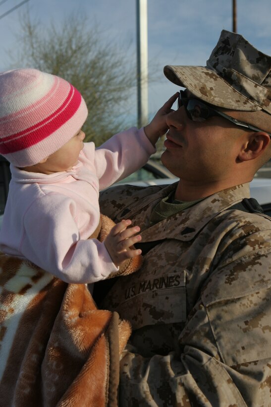Cpl. Efrain Scott, a Reno, Nev., native with Kilo Company, 3rd Battalion, 4th Marine Regiment, spends some final moments with his 10-month-old daughter, Julia, at the Combat Center Feb. 25, 2008, before he sets off on a deployment to Iraq.  3/4, also nicknamed ?Darkside? for their call sign they adopted during the beginning of Operation Iraqi Freedom, will be deploying to western Al Anbar Province, Iraq.  They are tasked with mentoring, monitoring and training the Iraqi security forces, maintaining security and assisting the local leaders to become better governing officials for their local government.