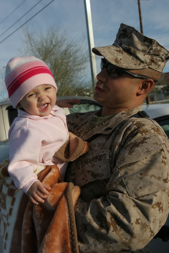 Cpl. Efrain Scott, a Reno, Nev., native with Kilo Company, 3rd Battalion, 4th Marine Regiment, shares some smiles with his 10-month-old daughter, Julia, at the Combat Center Feb. 25, 2008, before he sets off on a deployment to Iraq.  3/4, also nicknamed ?Darkside? for their call sign they adopted during the beginning of Operation Iraqi Freedom, will be deploying to western Al Anbar Province, Iraq.  They are tasked with mentoring, monitoring and training the Iraqi security forces, maintaining security and assisting the local leaders to become better governing officials for their local government.