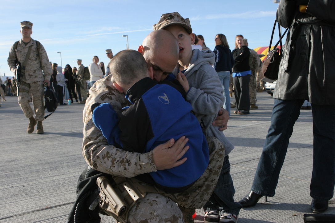 1st Sgt. Michael Miller, company first sergeant with Kilo Company, 3rd Battalion, 4th Marine Regiment, and a Denver native, hugs his two sons, Austin and Gabriel, just before he sets off on a seven month deployment to Iraq from the Combat Center Feb. 25, 2008.  3/4, also nicknamed ?Darkside? for their call sign they adopted during the beginning of Operation Iraqi Freedom, will be deploying to western Al Anbar Province, Iraq.  They are tasked with mentoring, monitoring and training the Iraqi security forces, maintaining security and assisting the local leaders to become better governing officials for their local government.