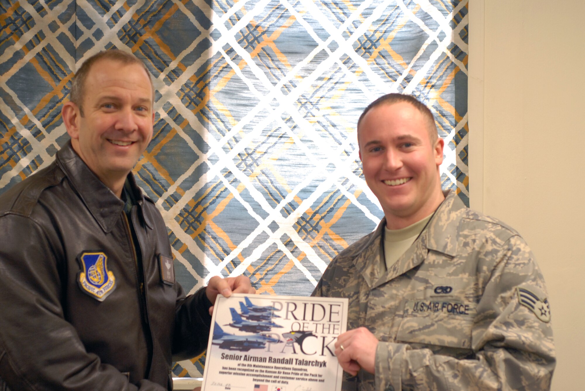 KUNSAN AIR BASE, South Korea --  Colonel Creig Rice 8th Fighter Wing vice commander, congratulates Senior Airman Randall Talarchyk from the 8th Maintenance Operations Squadron here Feb. 22. Airman Talarchyk was selected as the 8th Fighter Wing's Pride of the Pack for the week of Feb. 18. (U.S. Air Force photo/Staff Sgt. Alice Moore) 
