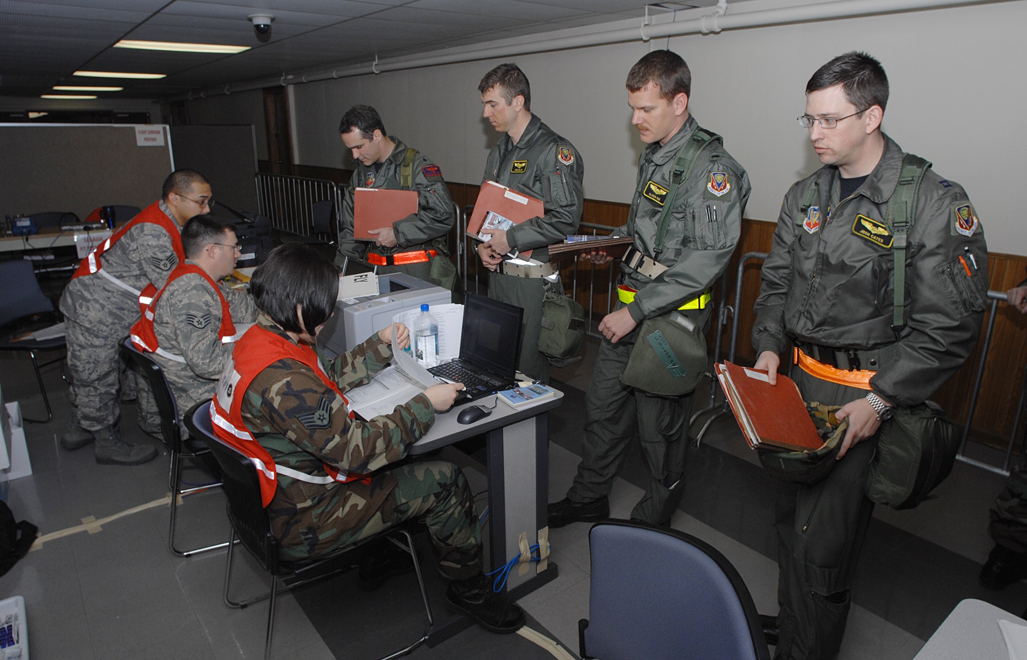 MOUNTAIN HOME AIR FORCE BASE, Idaho - Pilots and weapon systems officers proceed through the personnel deployment function line while staff members assist them with finalizing their mobility during Exercise Sharpshooter 08-04 Feb. 24. Mobility folders are used by unit deployment managers as a means to consolidate each deploying personnel's required paperwork to make processing for their deployment more streamlined.  The 366th Fighter Wing conducts exercises to prepare personnel and equipment for the upcoming March 2008 Operational Readiness Inspection. (U.S. Air Force photo/ Airman 1st Class Ryan Crane) 
