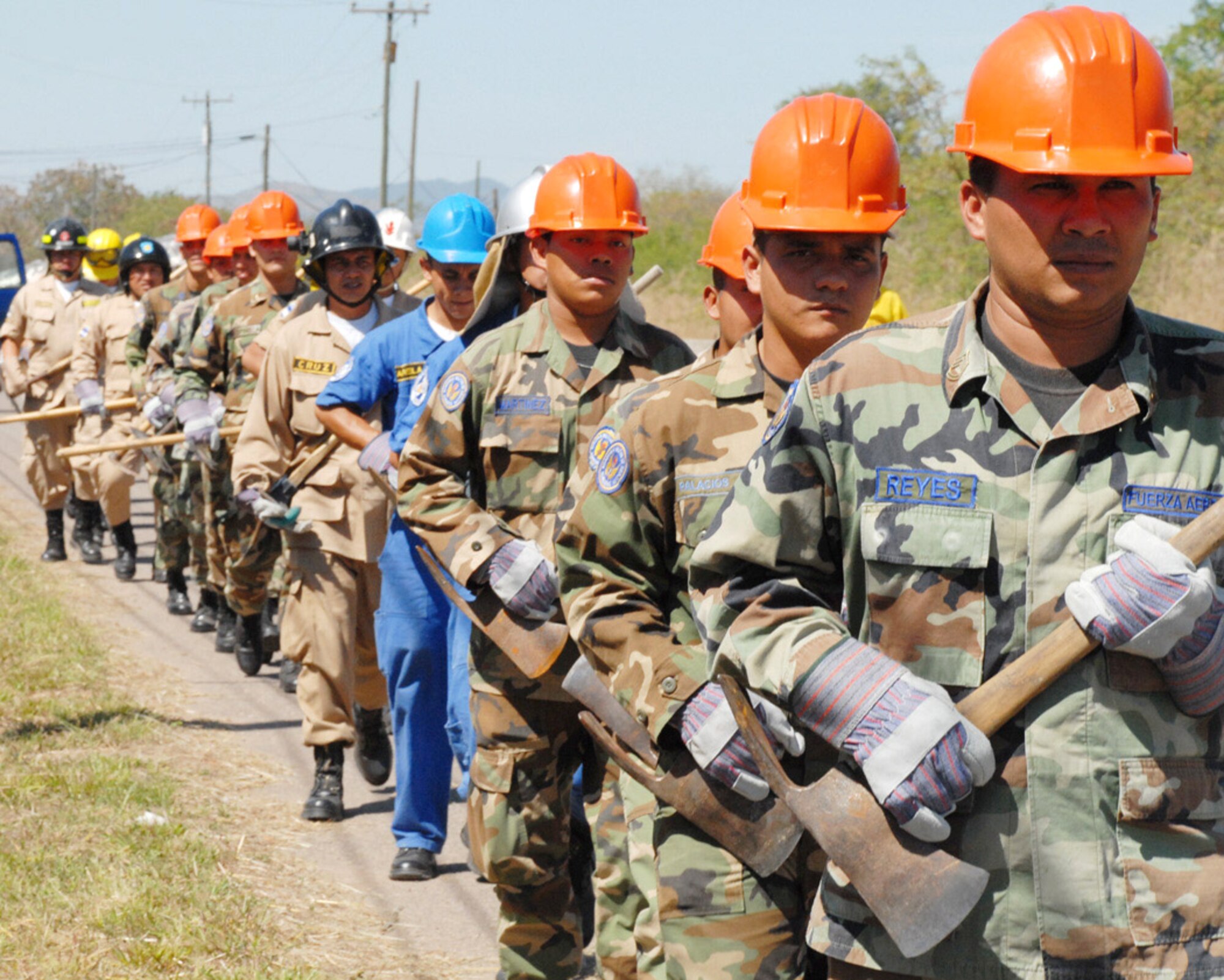 Honduran military and civilian firefighters march toward an area of Soto Cano Air Base, Honduras, to dig a fire break (a gap in vegetation or other combustible material that is expected to slow or stop the progress of a wildfire). The firefighters participated in a Joint Task Force-Bravo-sponsored firefighting subject matter expert exchange, a learning exposition for firefighters. During the exchange, a great level of importance is placed on land navigation and fighting wildfires. Hundreds of firefighters from fire departments across Honduras have participated in the exchange over the last two years. (U.S. Air Force photo/Tech. Sgt William Farrow) 