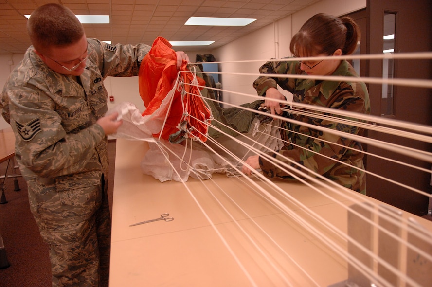 MOODY AIR FORCE BASE, Ga. -- Staff Sgt. Brandon Hatfield, 23rd Operations Support Squadron aircrew flight equipment craftsman, and Staff Sgt. Stephanie Mueller, 23rd OSS aircrew flight flight equipment journeyman, check the routing of an ejection seat recovery parachute's reefing line here Feb. 20 . The ejection seat is used in an A-10C Thunderbolt II. (U.S. Air Force photo by Airman 1st Class Gina Chiaverotti) 