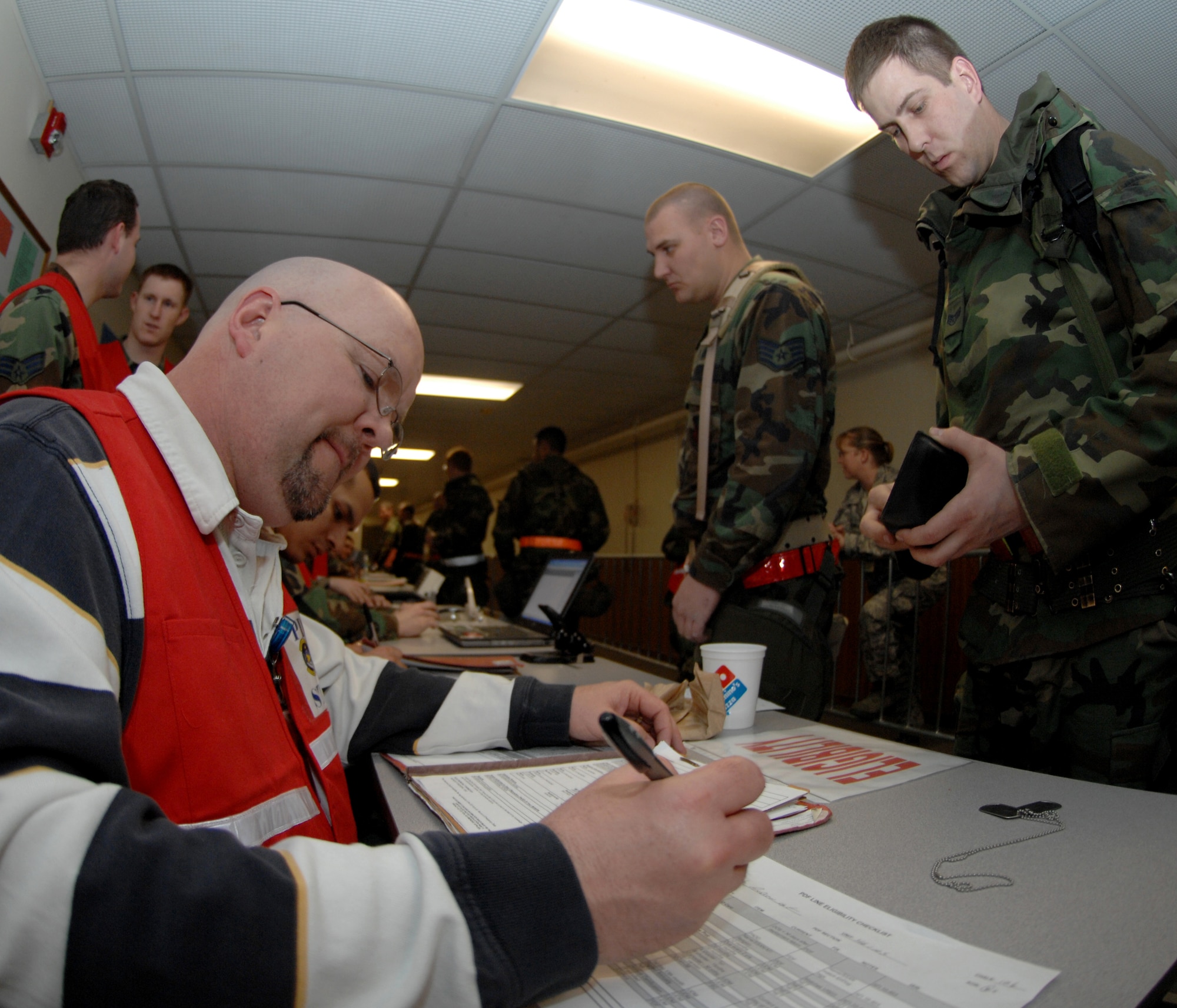 MOUNTAIN HOME AIR FORCE BASE, Idaho - David Crowden, 366th Mission Support Squadron customer service representative, checks training records and identification cards as Airmen process to deploy during Exercise Sharpshooter 08-04 Feb. 25. The 366th Fighter Wing conducts exercises to prepare personnel and equipment for the upcoming March 2008 Operational Readiness Inspection. (U.S. Air Force photo/ Airman 1st Class Stephany Miller)