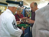 Chief Master Sgt. Rocky Hart, 919th Special Operations Wing command chief, sells samples of chili to prospective voters at the Santa Rosa Mall Chili Cook-off held Feb. 9 in Fort Walton Beach, Fla. Kim's Commando Chili, named for its cook, Master Sgt. Kim Sayer, 919th Maintenance Operations Flight, took first place in the competition for best judge's choice chili and third for team showmanship. Sergeant Sayer first introduced her award-winning recipe at the wing's Family Day Chili Competition December 2007 where she beat out Duke competitors to move up to the mall competition. (U.S. Air Force Photo/Leslie Henderson)