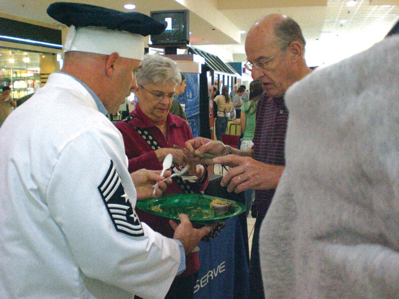 Chief Master Sgt. Rocky Hart, 919th Special Operations Wing command chief, sells samples of chili to prospective voters at the Santa Rosa Mall Chili Cook-off held Feb. 9 in Fort Walton Beach, Fla. Kim's Commando Chili, named for its cook, Master Sgt. Kim Sayer, 919th Maintenance Operations Flight, took first place in the competition for best judge's choice chili and third for team showmanship. Sergeant Sayer first introduced her award-winning recipe at the wing's Family Day Chili Competition December 2007 where she beat out Duke competitors to move up to the mall competition. (U.S. Air Force Photo/Leslie Henderson)