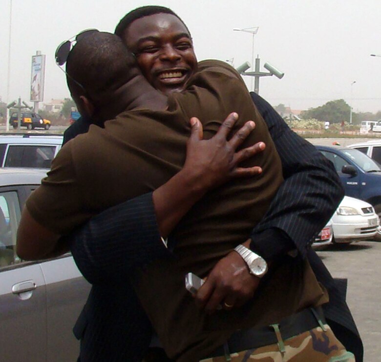 Air Force Staff Sgt. Hodonou Motepke (front), a heating, ventilation and air conditioning technician, and native African, embraces his older brother, Clement Motepke, Feb. 21, as they greet one another for the first time in a decade. This is Sergeant Motepke's first trip back to Africa since he left in 1998. The U.S. military presence in Ghana is in support of U.S. President George Bush's visits to the continent. (U.S. Air Force photo/Tech. Sgt. Denise Johnson) 