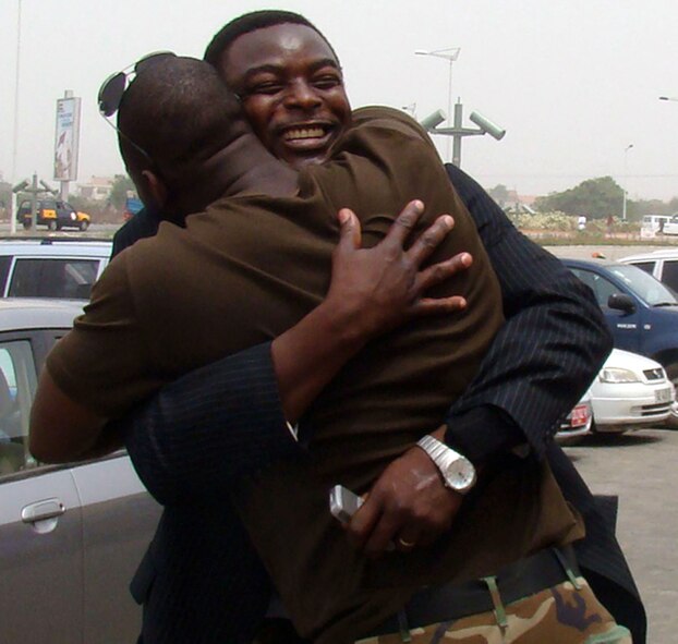 Air Force Staff Sgt. Hodonou Motepke (front), a heating, ventilation and air conditioning technician, and native African, embraces his older brother, Clement Motepke, Feb. 21, as they greet one another for the first time in a decade. This is Sergeant Motepke's first trip back to Africa since he left in 1998. The U.S. military presence in Ghana is in support of U.S. President George Bush's visits to the continent. (U.S. Air Force photo/Tech. Sgt. Denise Johnson) 