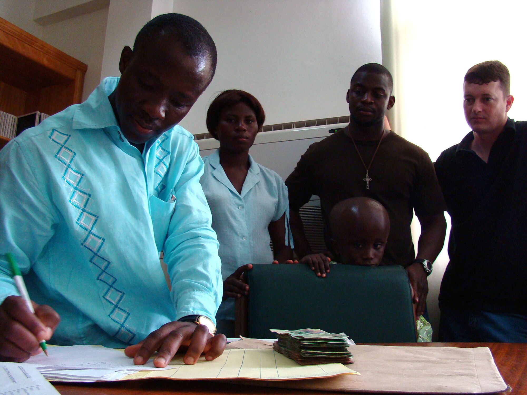 Dr. Pat Bankahat , documents Alex Vadis Teye's medical records Feb. 22 at the Korle Bu Teaching Hospital in Ghana, Africa. Alex, 9, visited the hospital to accept a donation from Armed Forces servicemembers in response to his parents' plea for help to pay for the boy's surgery. Alex suffers from hydrocephalus, a common birth defect which causes an excess of water in the brain. Dr. Bankahat is the head of neurosurgery at the hospital. Staff Sgt. Hodonou Motepke, a U.S. Air Force heating, ventilation and air conditioning technician, and native African, initiated a drive to raise the money to pay for Alex's surgery. This is Sergeant Motepke's first trip back to Africa in 10 years. The U.S. military presence in Ghana is in support of U.S. President George Bush's visits to the continent. (U.S. Air Force photo/Tech. Sgt. Denise Johnson) 