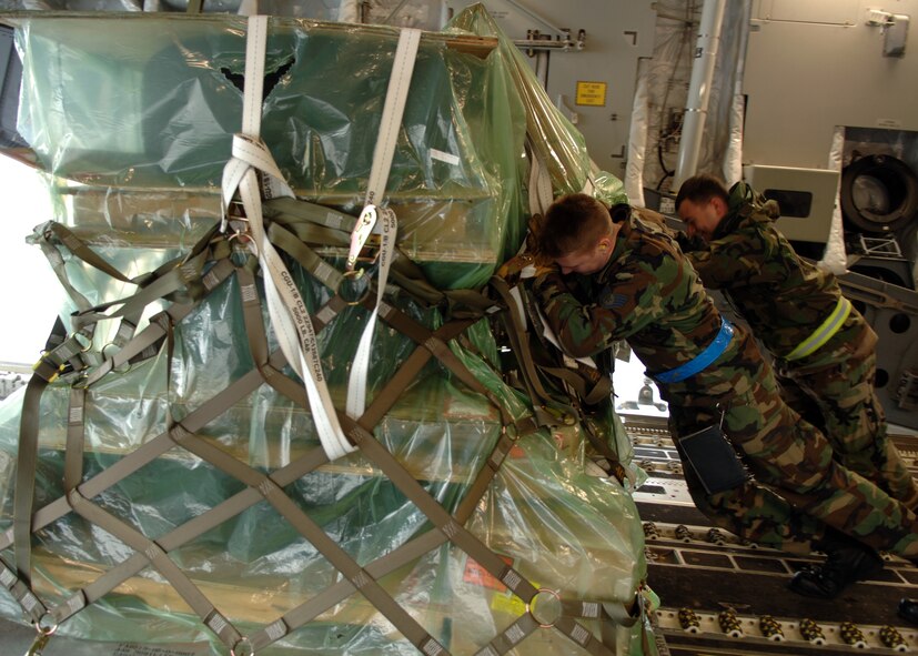 Staff Sgt. Kris Neal (left), 723rd Air Mobility Squadron aerial port expeditor team chief, and Senior Airman Scott Jankielsztajn, Joint Mobility Processing Center augmentee, offload cargo at Ramstein Feb. 7. The cargo movement is in support of Joint Task Force-Nomad Fire in Africa. Photo by Airman 1st Class Kelly LeGuillon