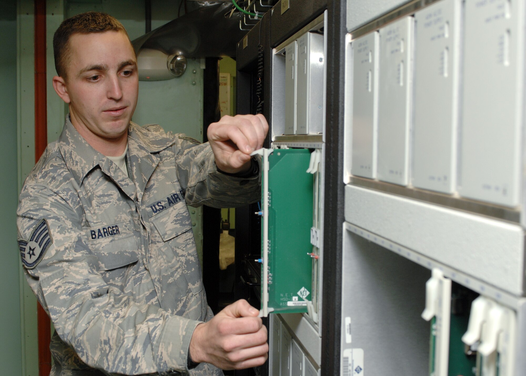 BAGRAM AIR BASE, Afghanistan - Staff Sgt. Andrew Barger, 455th Expeditionary Mission Support Squadron, Network Infrastructure Supervisor, replaces a card on a promina 800 which groups all services for satellite link here Feb. 20. Barger was recently named Warrior of the Week for his outstanding work in COMM. Barger's home unit is the 54th Combat Communications Squadron, Warner-Robins Air Force Base, Ga. (U.S. Air Force photo by Master Sgt. Demetrius Lester) 
