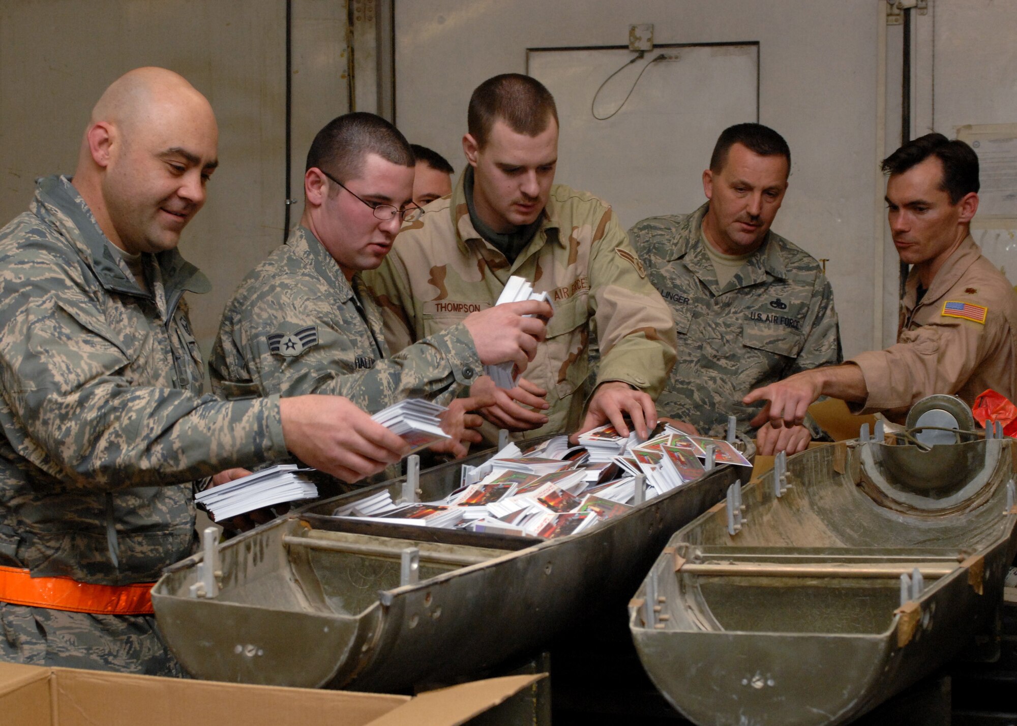 BAGRAM AIR BASE, Afghanistan - Conventional munitions crew members of the 455th Expeditionary Maintenance Squadron AMMO, load leaflets into a dispenser here Feb. 16. The leaflets were dropped by two F-15Es in southern Afghanistan to gain support of the Afghan National Government and rid out the Taliban. (U.S. Air Force photo by Master Sgt. Demetrius Lester)