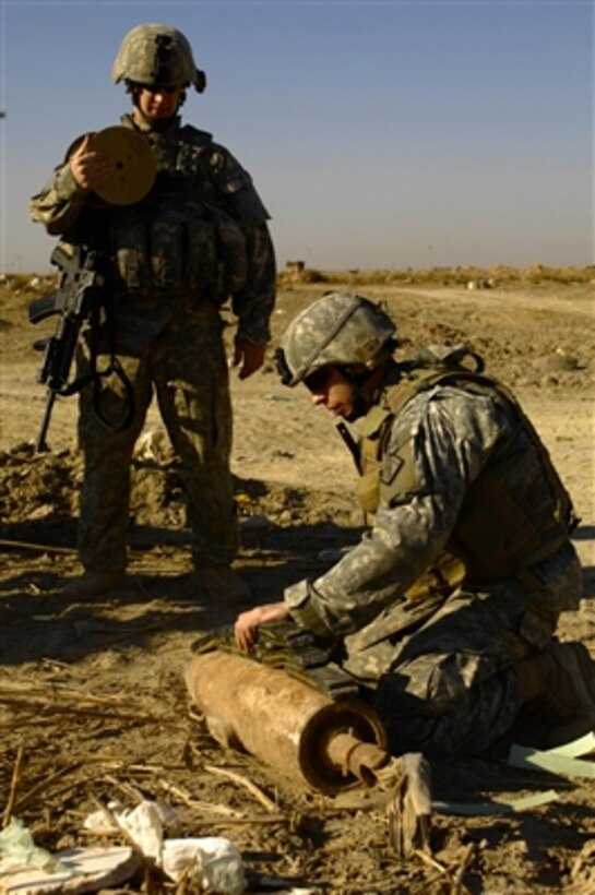 U.S. Army Staff Sgt. Tim Brochu (left) and Sgt. Brian Hutchins prepare to detonate unexploded ordnance found near Forward Operating Base Rustamiyah in Baghdad, Iraq, on Feb. 22, 2008.  Brochu and Hutchins, both of 761st Explosive Ordnance Disposal, will destroy the ordnance with a controlled explosion.  