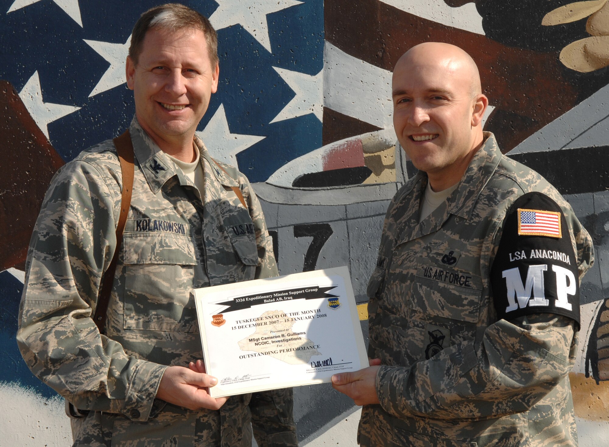 BALAD AIR BASE, Iraq -- Master Sgt. Cameron Guilliams, 332nd Expeditionary Security Forces Squadron investigations NCOIC, receives the 332nd Expeditionary Mission Support Group Tuskegee Senior NCO of the Month award from Col. William Kolakowski, 332nd EMSG commander, Jan. 24. Sergeant Guilliams, who is deployed from the 92nd Security Forces Squadron at Fairchild, received the award for outstanding performance from Dec. 15, 2007 to Jan. 15.  (Courtesy photo)