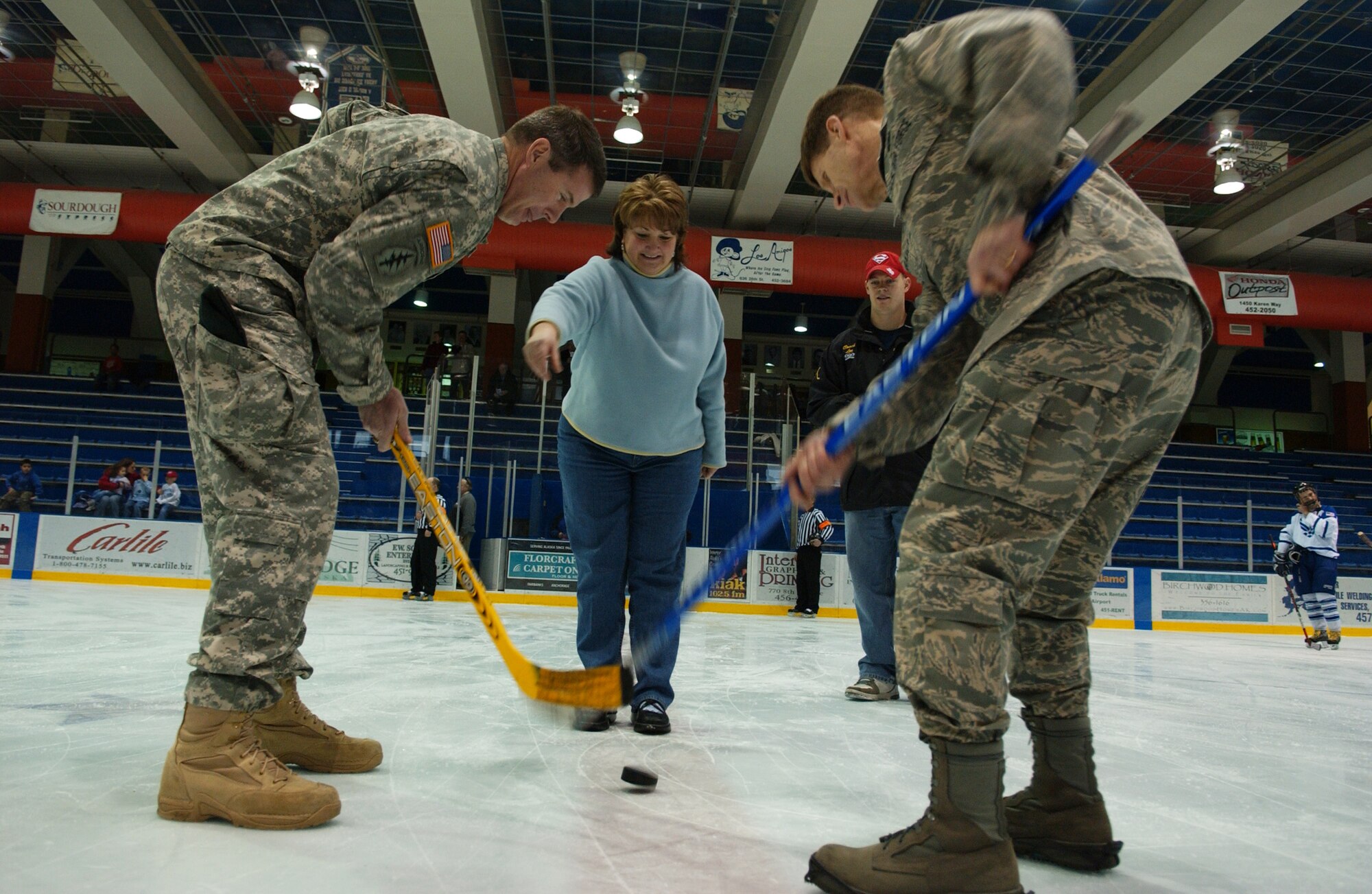 EIELSON AIR FORCE BASE, Alaska -- Fairbanks Mayor Terry Strle drops the honorary puck while Brig. Gen. Mark Graper, 354th Fighter Wing commander, right, representing the Eielson Icemen faces off with Lt. Col. Ronald Johnson representing the Fort Wainwright Grizzlies Feb. 23 at the Big Dipper Ice Arena. The Eielson Icemen faced off against the Fort Wainwright Grizzlies in the 12th annual Commander's Cup, which was a free game for military families to enjoy. (U.S. Air Force Photo/Airman 1st Class Jonathan Snyder)