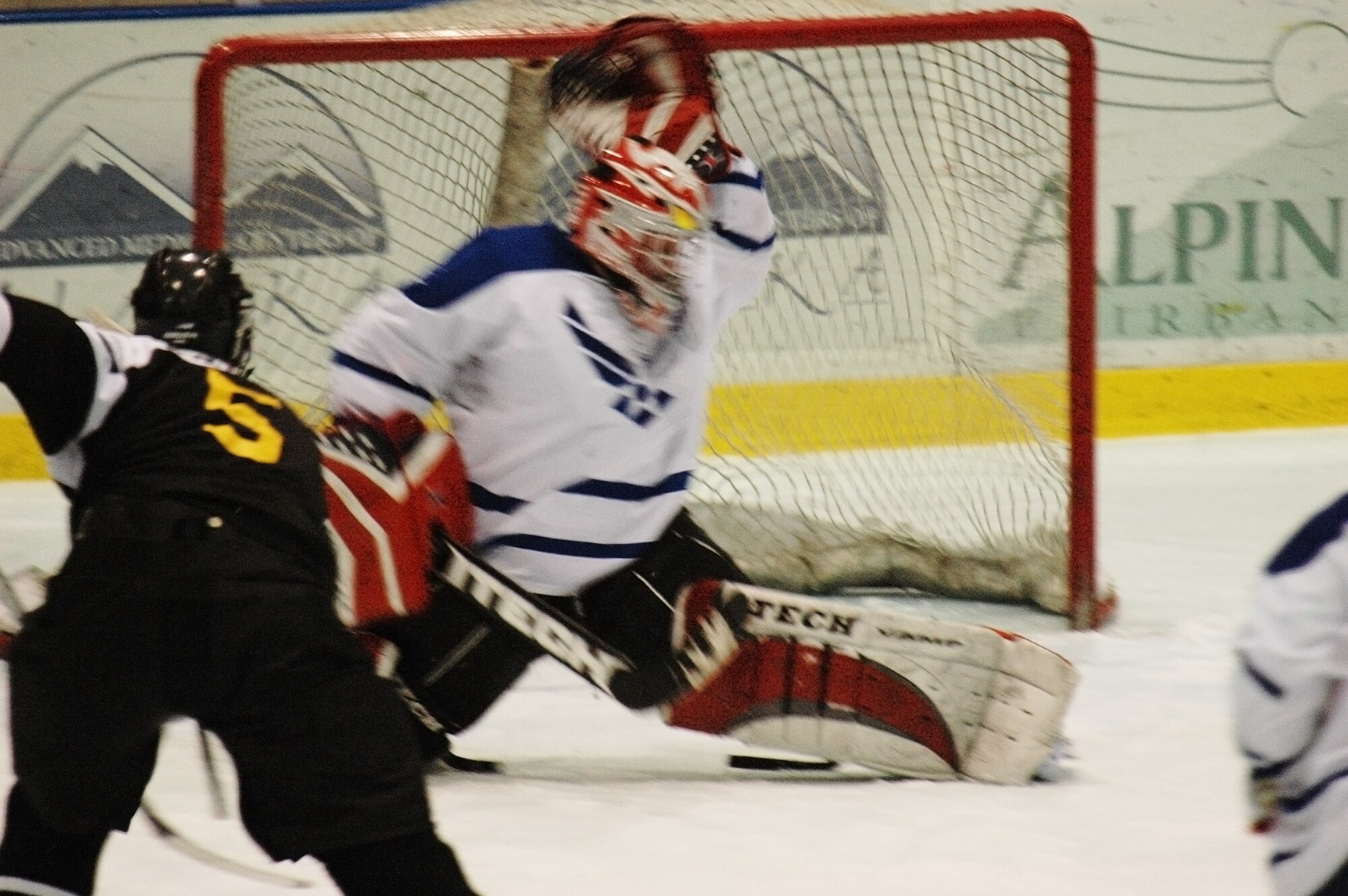 EIELSON AIR FORCE BASE, Alaska -- Jeffrey Dwyer blocks a shoot at the goal from Shawn Hunter Feb. 23 at the Big Dipper Ice Arena. The Eielson Icemen faced off against the Fort Wainwright Grizzlies in the 12th annual Commander's Cup, which was a free game for military families to enjoy. Dwyer is assigned to the 354th Logistics Readiness Squadron. (U.S. Air Force Photo/Airman 1st Class Jonathan Snyder)